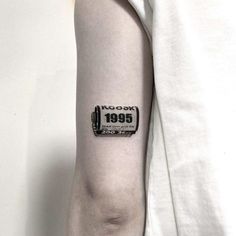 a black and white photo of a camera tattoo on the left upper half of the arm