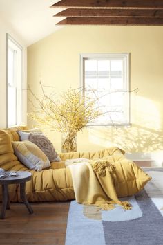 a living room filled with furniture and a vase on top of a table next to a window