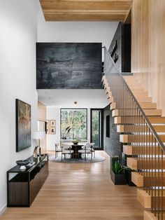 a living room filled with furniture next to a stair case and wooden floored stairs