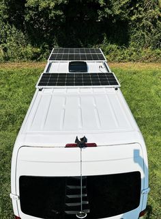 the back end of a white truck with solar panels on it