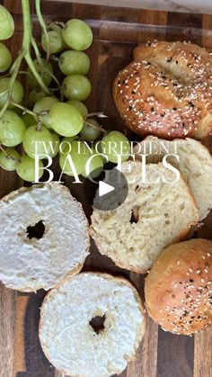 bagels and grapes on a wooden cutting board