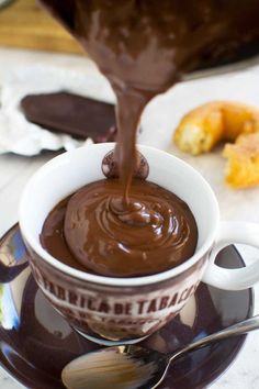 chocolate sauce being poured into a coffee cup