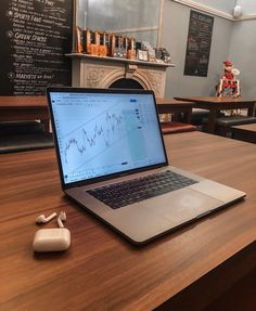 an open laptop computer sitting on top of a wooden table