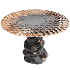 a black and gold pedestal with an intricate design on the top, sitting in front of a white background