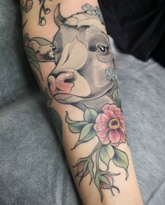 a cow with flowers on it's arm is shown in this tattoo style photo