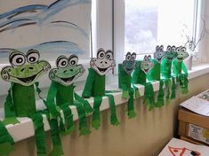 the paper frogs are lined up on the window sill