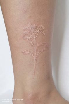 a woman's foot with a flower tattoo on it