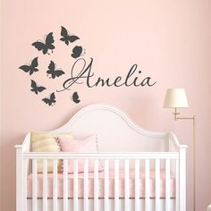 a baby's room with pink walls and butterflies on the wall