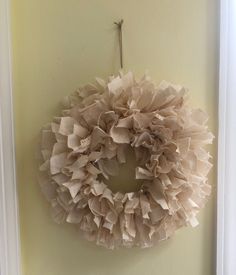 a white wreath hanging on the wall next to a door with a key in it