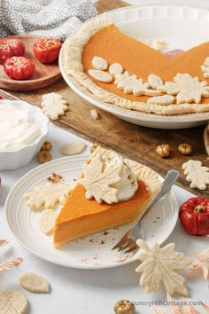 a slice of pumpkin pie sitting on top of a white plate next to other plates