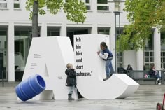 two children are playing on the letters in front of a building