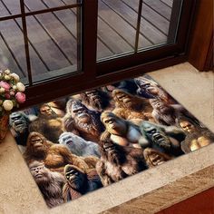 an area rug with gorillas and other animals on it next to a vase full of flowers