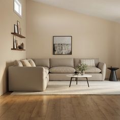 a living room with a couch, coffee table and pictures on the wall above it