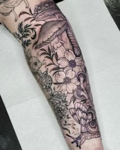 a woman's arm with flowers and birds on it