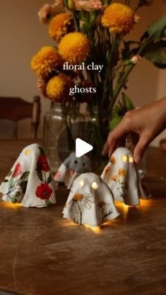 someone is decorating small elephant figurines on a table with flowers in the background