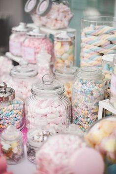 many jars filled with different types of candy