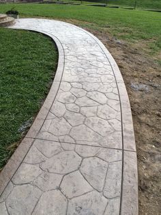 a stone path in the middle of a grassy field