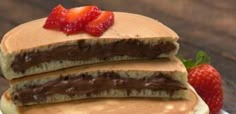 stack of pancakes with chocolate and strawberries on top