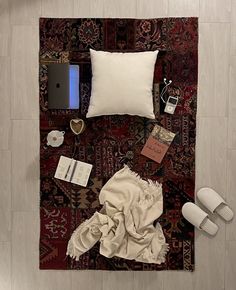 an overhead view of a bed with pillows, blankets and other items on the floor