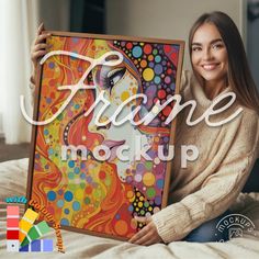 a woman sitting on a bed holding up a painting with the words frame mockup