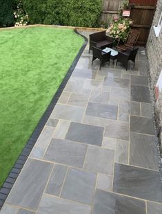 an outdoor patio area with grass and chairs