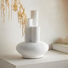 a white vase sitting on top of a table