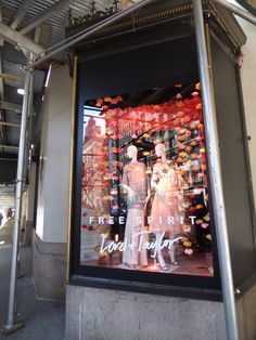 a window display with mannequins in front of it