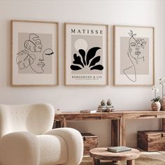 three framed art pieces hang on the wall above a chair and coffee table in a living room