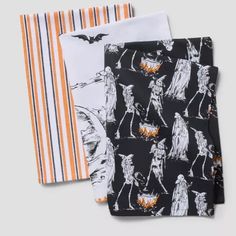 three halloween napkins on top of each other, one with an image of skeletons and pumpkins