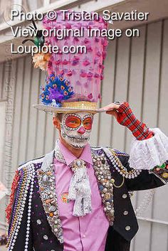 a man in a costume with a cake on top of his head and face painted like a skeleton