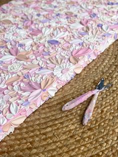 a pair of pliers sitting on top of a straw mat next to a piece of cloth