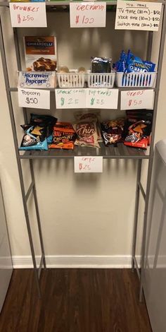 a metal shelf filled with lots of food on top of a hard wood floor next to a white wall