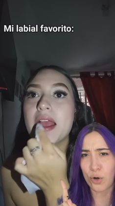 two women with purple hair are posing for the camera and one is brushing her teeth