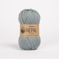 a ball of yarn with the words nepal on it in grey and brown lettering, against a white background