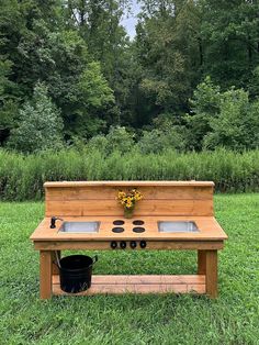 a wooden bench sitting in the middle of a field with potted plants on it