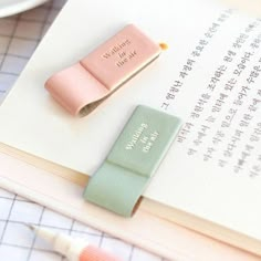 two erasers sitting on top of an open book