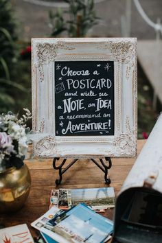 the bride's wedding sign is displayed in front of a table with flowers and books