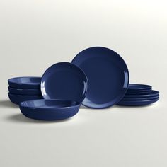 blue plates stacked on top of each other in front of a white background with one empty plate