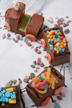 there are three pieces of chocolate cake with candy on the top and one slice missing