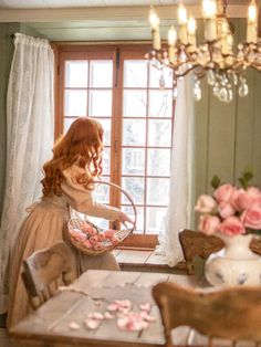 a woman in a dress is holding a basket with pink flowers on it and looking out the window