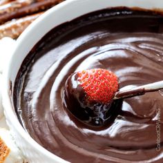 a bowl filled with chocolate and some crackers