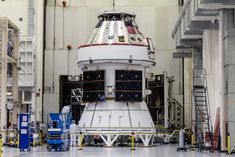 the space shuttle is being worked on in an assembly line, with workers around it