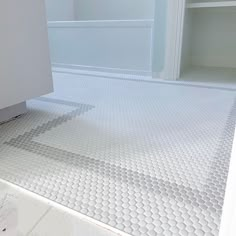 a bathroom with white tile flooring next to a bathtub and shower stall door