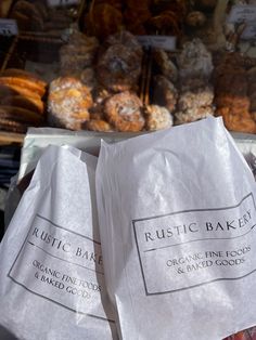 two paper bags sitting on top of each other in front of some doughnuts