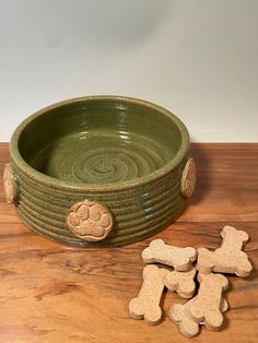 there is a bowl with two dogs on it and some biscuits in front of it