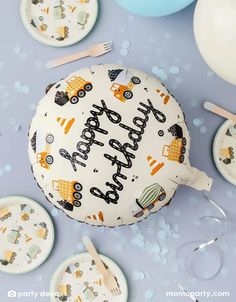 a birthday cake sitting on top of a table next to plates and cups with forks