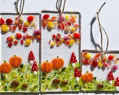 three small cards with candy decorations hanging from twine strings on a white surface, each decorated in different shapes and sizes