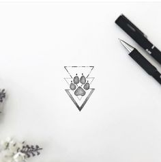 a pen sitting on top of a white paper next to some flowers and a pair of scissors