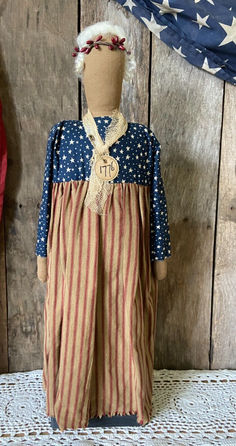 an american flag dress is displayed on a mannequin's head, with the american flag in the background