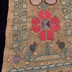 an old piece of cloth with flowers and butterflies on it, sitting on a table